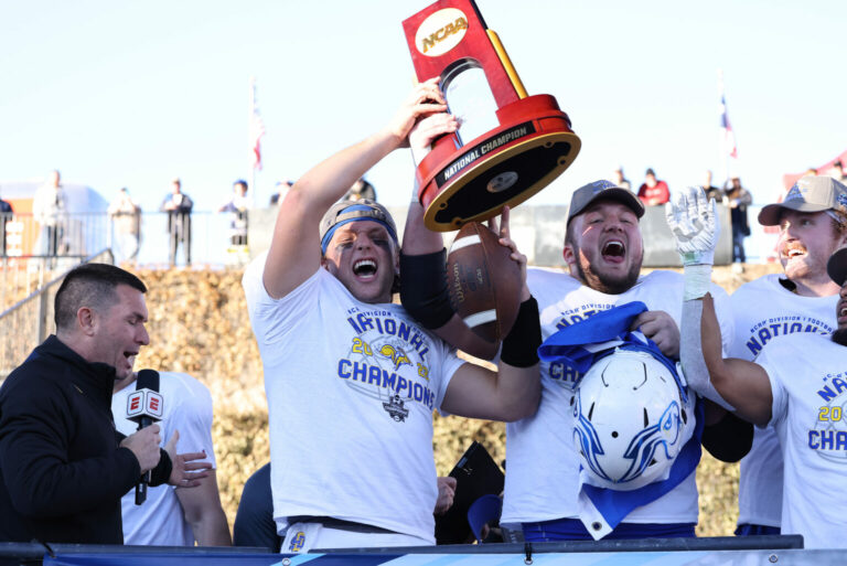 South Dakota State quarterback Mark Gronowski and fellow team captain Mason McCormick hoist the championship trophy after beating North Dakota State 45-21 in the FCS title game Jan. 8, 2023, in Frisco, Texas. Inertia photo by Dave Eggen