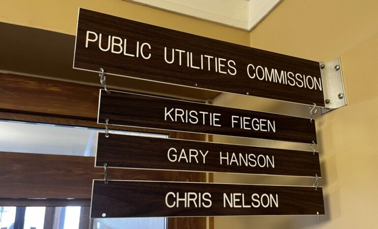 A sign displays the names of the state’s three elected public utilities commissioners outside of their Pierre office in January 2023.