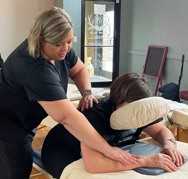 Olawa Bruhjell demonstrates the use of a table top massage chair. Aberdeen Insider photo by Elisa Sand