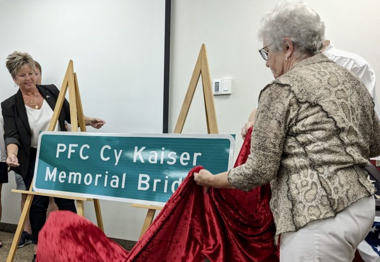 Cheryl Kaiser, left, and Irene Kaiser unveil a sign dedicating a bridge along U.S. Highway 12 near Mina in memory of Pfc. Cy Kaiser, who died in action in World War II. Cheryl is Cy's granddaughter and Irene is his daughter-in-law. Aberdeen Insider photo by Scott Waltman