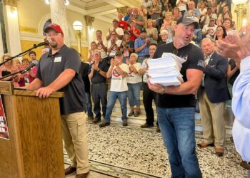 ‘Bossly bill’ aimed at preventing land survey abuses wins committee approval 5 Landowners Mark Lapka of McPherson County, left, and Jared Bossly of Brown County, holding petitions with about 2,000 signatures, speak at the state Capitol in Pierre on July 6, demanding a prohibition against carbon capture pipeline companies gaining access to land against a landowner’s will. South Dakota Searchlight photo by Joshua Haiar
