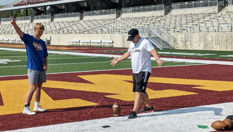 Kicking coach Chris Sailer offers kicking tips to Joey Dallmann of Aberdeen on Saturday, July 22 at Dacotah Bank Stadium. Aberdeen Insider photo by Scott Waltman