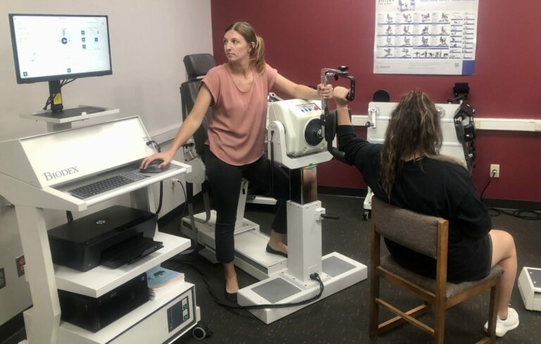 Jessica Talmage, director of Nora Staael Evert Human Performance Laboratory at Northern State University, left, works with softball player Tevan Bryant. Photo courtesy of Northern State University