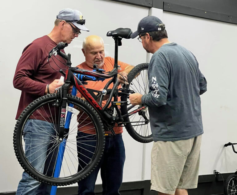Lions Club members, from right, Tom Wensmann, Rich Merriman and Mark Malchow work to refurbish a bike for the Aberdeen Lions Club Build-A-Bike program. The program takes used bikes – many donated by the Aberdeen Police Department – fixes them up and donate them to kids in need. Courtesy photo from the Lions Club