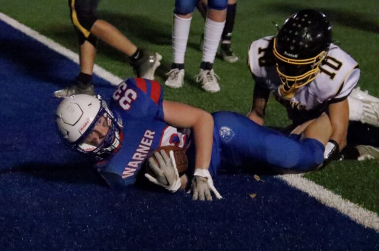 Warner's Charlie Delany looks up after scoring a second-quarter touchdown during the Monarchs 57-0 Class 9A playoff win over Colman-Egan. Making the tackle for the Hawks is Jackson Wright. Aberdeen Insider photo by Robb Garofalo
