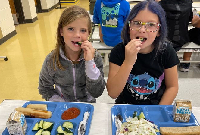 Lincoln Elementary students, from left, Addison Torbert and Tillie Schiel, enjoy slices of cucumber for the South Dakota Crunch Off. Courtesy photo from the Aberdeen Public School District