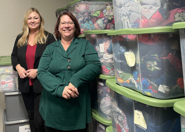 Heather Smith, left, and Louise Schwab stand among totes of clothes available through Aberdeen Area Foster Closet. Aberdeen Insider photo by Elisa Sand