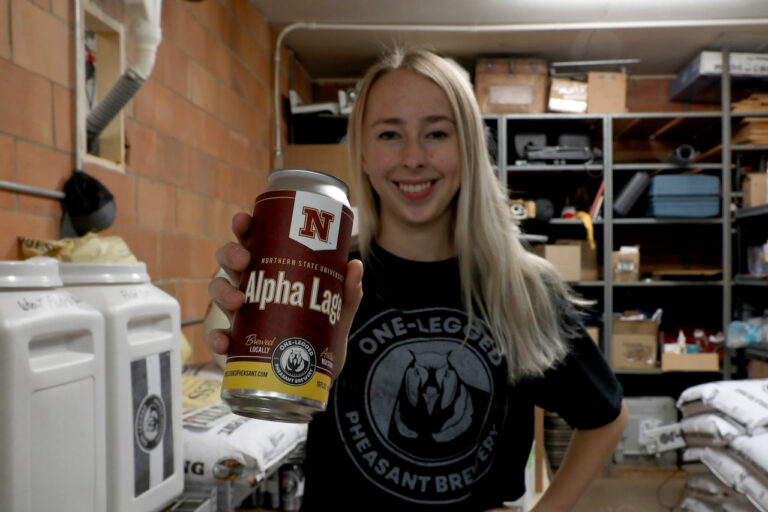 Jess Splichal holds a cn of Alpha Lager. Courtesy photo from Northern State University