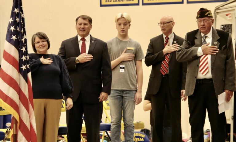 Pastor Andrea Johnson; U.S. Sen. Mike Rounds, R-S.D.; Central High School student Ryder Vrchota; Central High School Principal Jason Uttermark and Aberdeen veteran Ron Korgman recite the Pledge of Allegiance Friday, Nov. 10 during the Veterans Day program at Central High School. Aberdeen Insider photo by Scott Waltman
