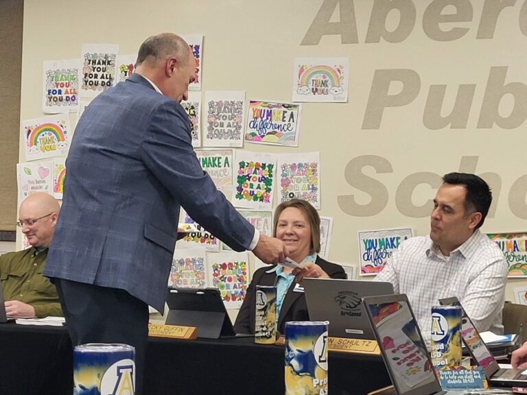 Holgate Principal Bo Beck hands kindness feathers out to school board members during a meeting on Monday, Feb. 12. Aberdeen Insider photo by Symmone Gauer