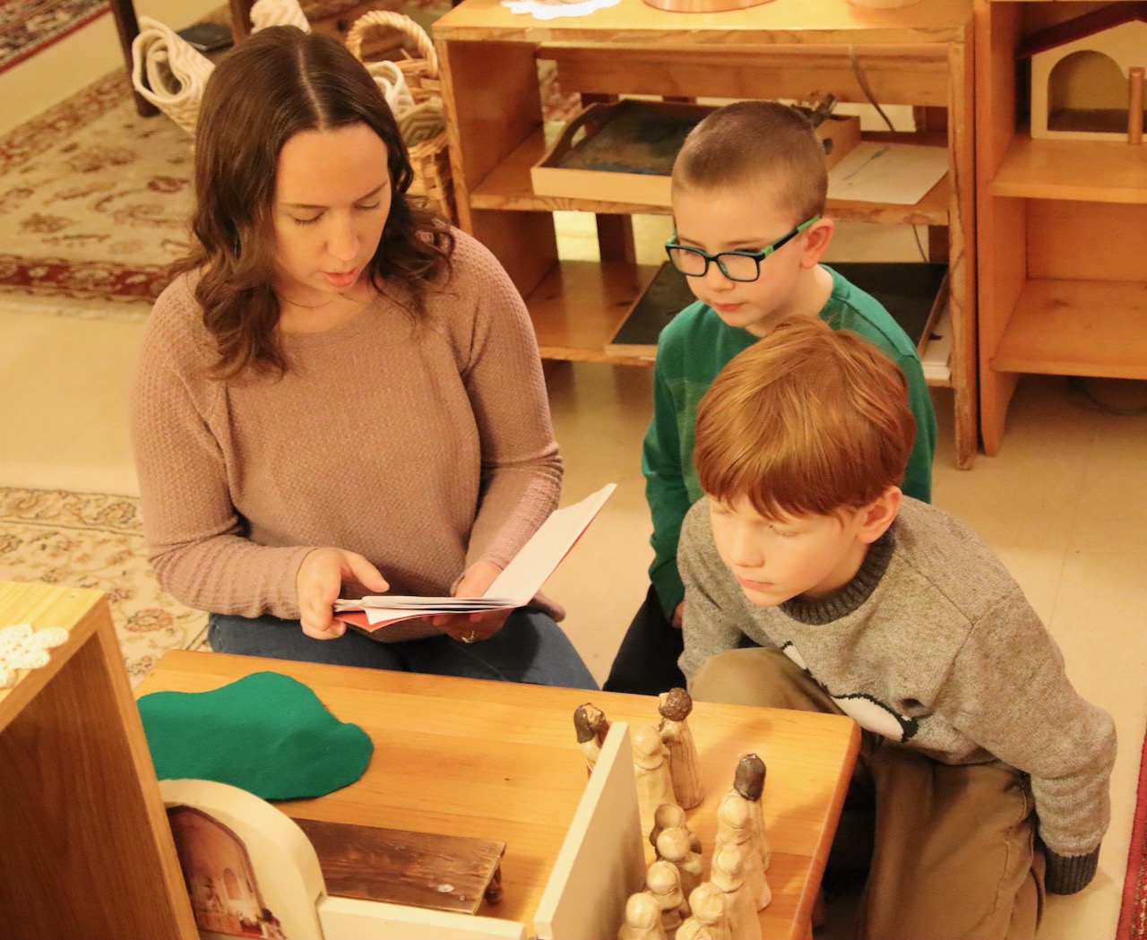 Katie Eskro, left, lead catechist for the atrium programs at Roncalli, reviews a station about the Last Supper with Michael Pain, center, and Lewis Schaff. Aberdeen Insider photo by Elisa Sand