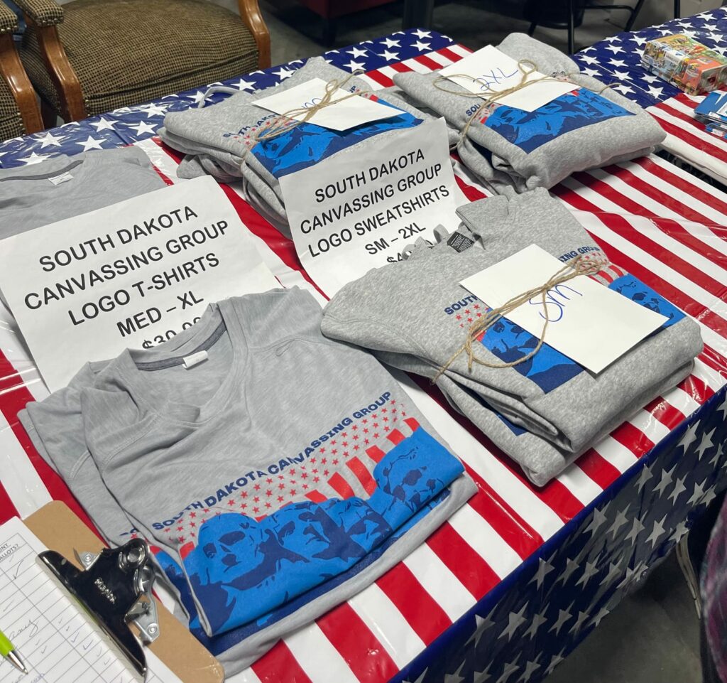 T-shirts for sale at a South Dakota Canvassing event at the Military Heritage Alliance in Sioux Falls on Oct. 19, 2023. The group was formed after My Pillow founder Mike Lindell held his cyber symposium in Sioux Falls in August 2021. South Dakota News Watch file photo
