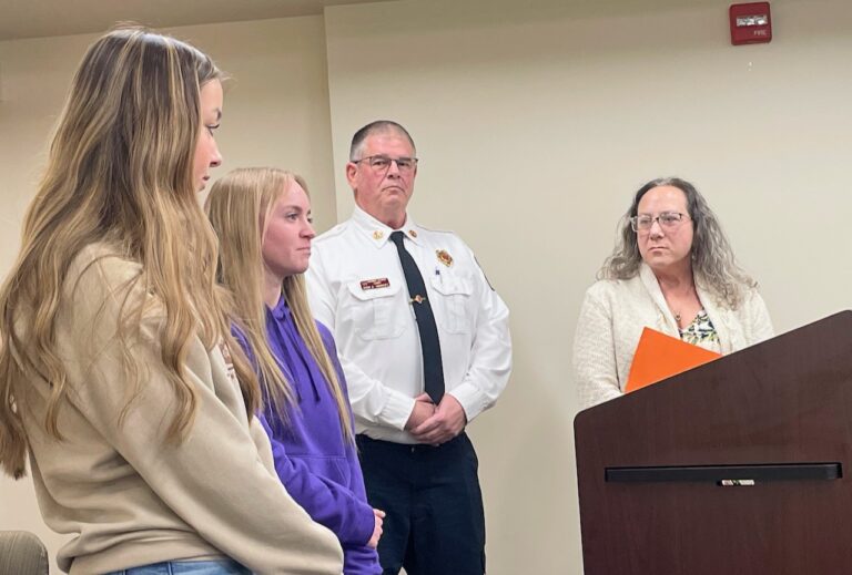 Central students, from left, Emma Kieth and Aurelia Steiger stand with Aberdeen Fire & Rescue's Keith Shariski and ATEC Academy teacher Karen De Brine as they visit with the school board about the district's new emergency medical responder course. Aberdeen Insider photo by Elisa Sand.