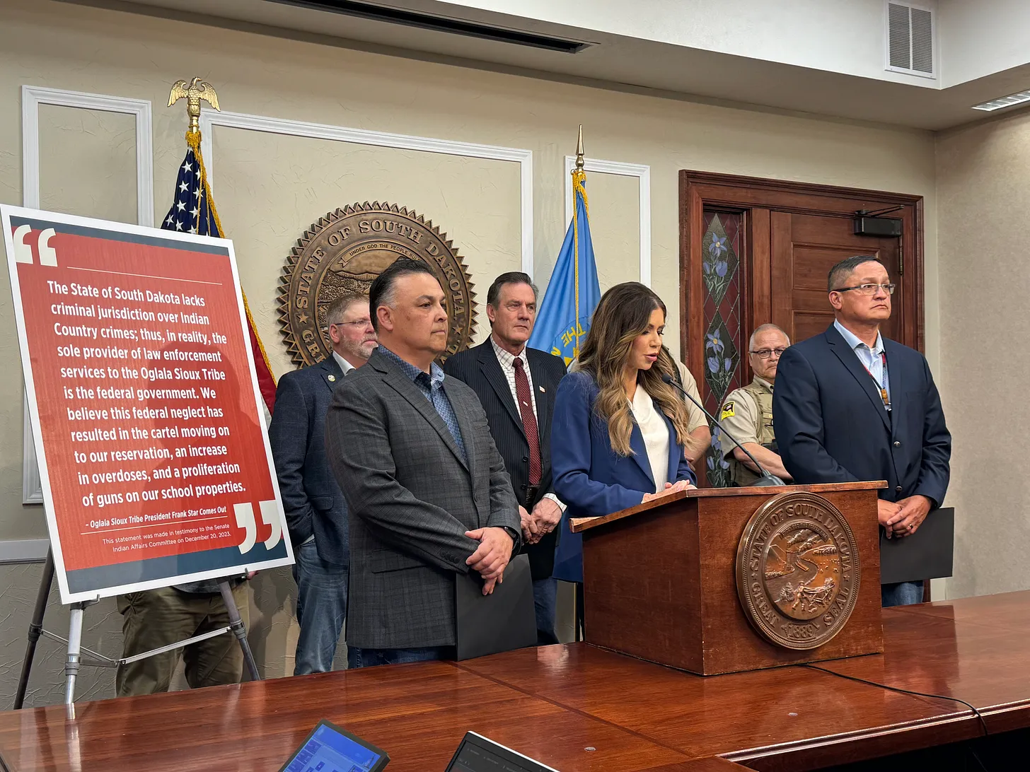Amid political firestorm, Gov. Noem falls back to border and reservation criticisms 1 Gov. Kristi Noem holds a press conference in the state Capitol flanked by other state officials and lawmakers. Dakota Scout photo by Austin Goss.