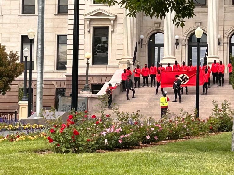 About two dozen uniformed masked men march around area landmarks Saturday. Courtesy photo.