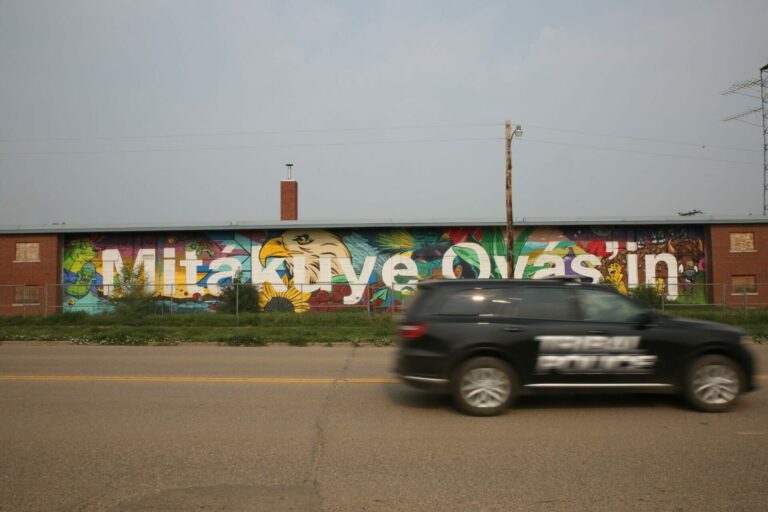 A tribal police car drives past a boarded up apartment complex on Main Street of Eagle Butte, South Dakota on the Cheyenne River Indian Reservation. South Dakota Searchlight photo by Makenzie Huber.