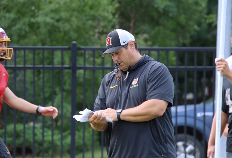 Northern State head football coach Mike Schmidt checks a play sheet during practice on the athletic and recreation field. Aberdeen Insider photo by Robb Garofalo.