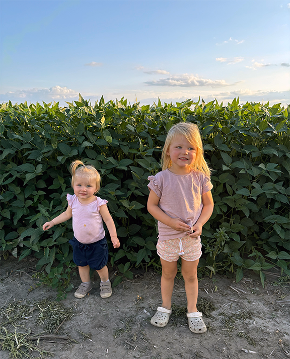 The granddaughters of Mike and Monica McCranie of Claremont stand in front of one of the McCranie soybean fields. Courtesy photo.