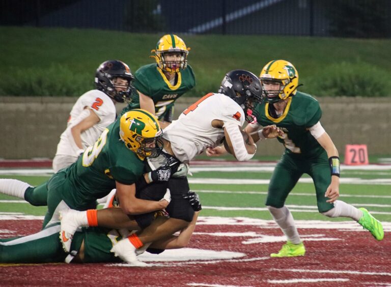 Aberdeen Roncalli's Brooks Jett, bottom, Jean Anthony Thomas, left, and Aiden Fisher, right swarm to Mobridge-Pollock's Mack Saxon during the second quarter Friday, Sept. 13 at Dacotah Bank Stadium. The Cavaliers won 42-0. Aberdeen Insider photo by Robb Garofalo.