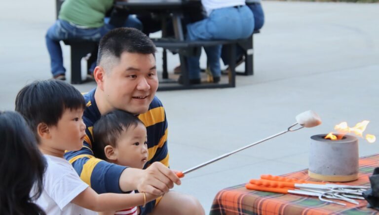 Bo Wang helps, Yujun Wang, left, and Yuden Wang roast a marshmallow for their s'more at the Aberdeen Downtown Association Campfire Session on Friday, Sept. 20 at Malchow Plaza. Aberdeen Insider photo by Elisa Sand.