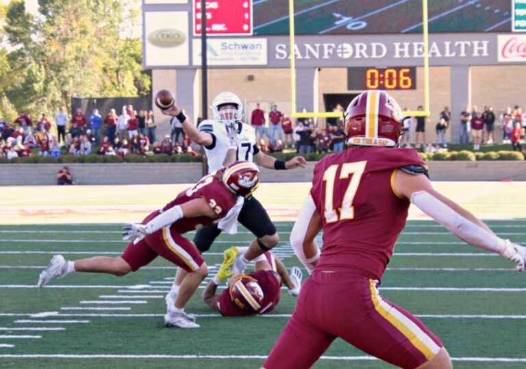 Northern State's Gabe Gutierrez grabs the feet of Bemidji State quarterback Sam McGrath while Matt Baker adds pressure forcing a bad throw and stopping a game-winning two-point conversion attempt Saturday, Oct. 5 at Dacotah Bank Stadium. The Wolves won their homecoming game 14-13. Aberdeen Insider photo by Robb Garofalo.