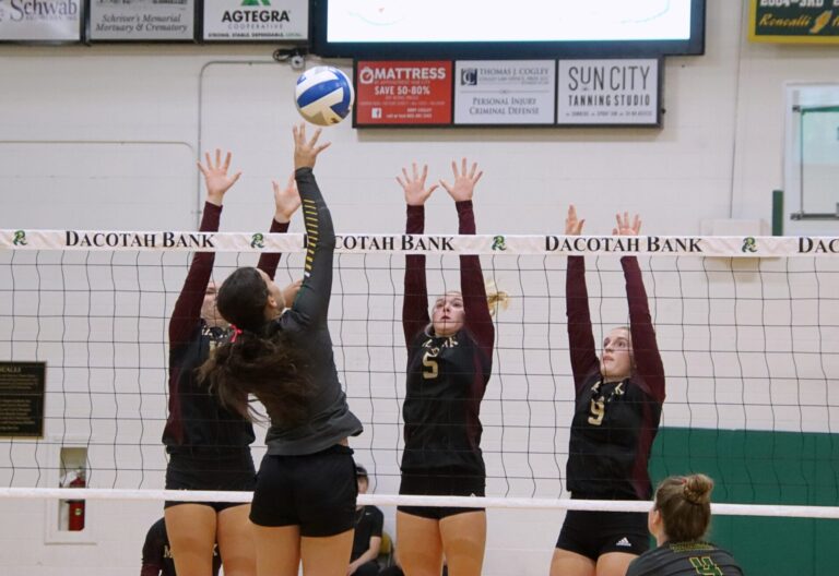 Aberdeen Roncalli's Gabby Thomas tips the ball over Milbank's Avery Schuneman, right, Isabella Anderson and Kenzie Kooima during the second set Tuesday, Oct. 22 at the Roncalli Gym. Aberdeen Insider photo by Robb Garofalo.
