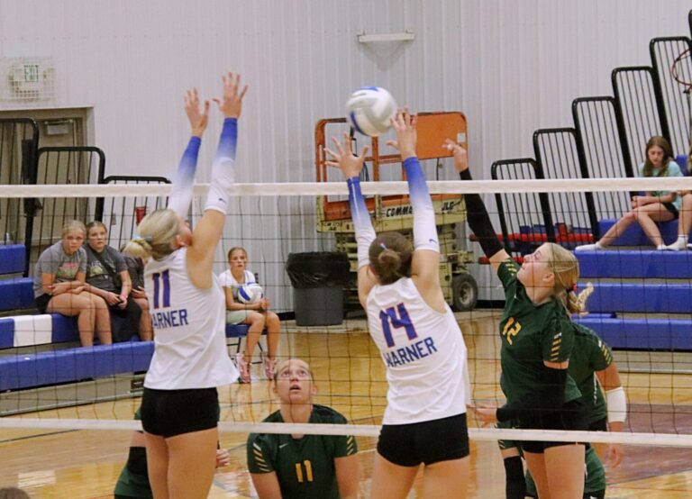 Warner's Olivia Marcuson (14) and Kyleigh Schopp go up for the block against Aberdeen Roncalli's McKenna O'Keefe during their match on Oct. 1 in Warner. The Monarchs won the battle. Aberdeen Insider photo by Robb Garofalo.