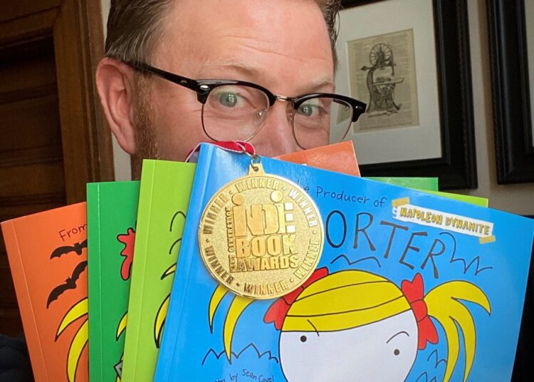Sean Covel hides behind a selection of "Porter the Hoarder" books he's published. He is the keynote speaker at Northern State University's Learning Expo on Sept. 30. Courtesy photo.