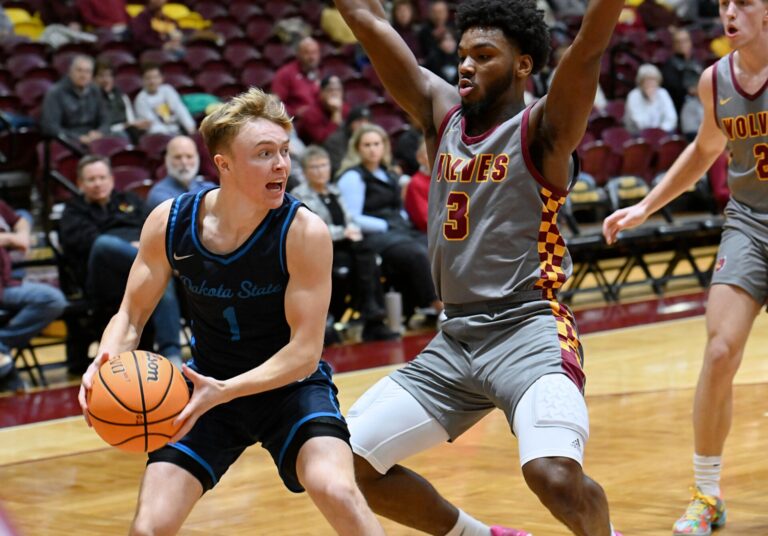 Dakota State's Lane Tietz looks to pass along the baseline during the first half against Northern State on Nov. 19 in Wachs Arena. Defending for Northern is Marcus Burks. Tietz is a freshman from Groton who finished with 15 points. Aberdeen Insider photo by Robb Garofalo.