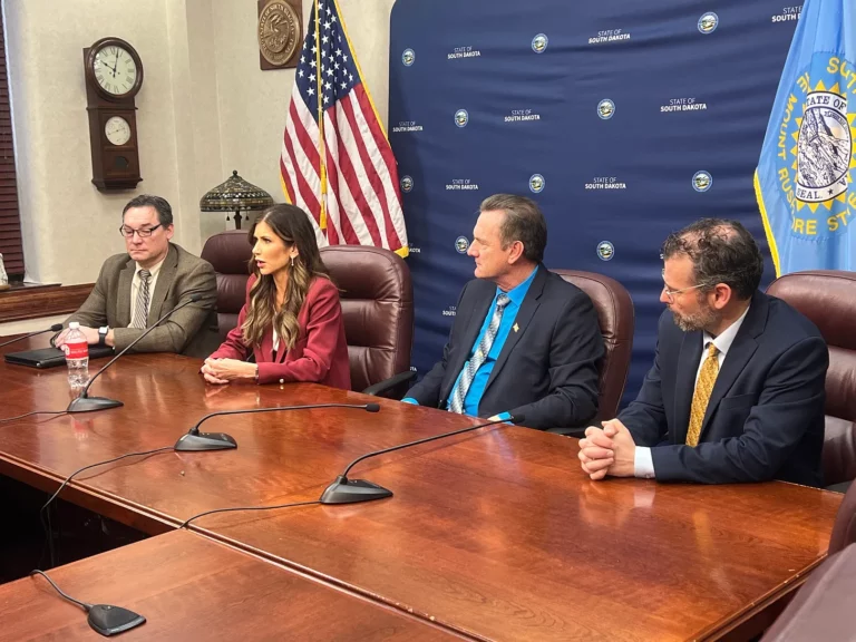 Gov. Kristi Noem speaks to reporters while flanked by Lieutenant Governor Larry Rhoden and other cabinet secretaries. Dakota Scout photo by Austin Goss.