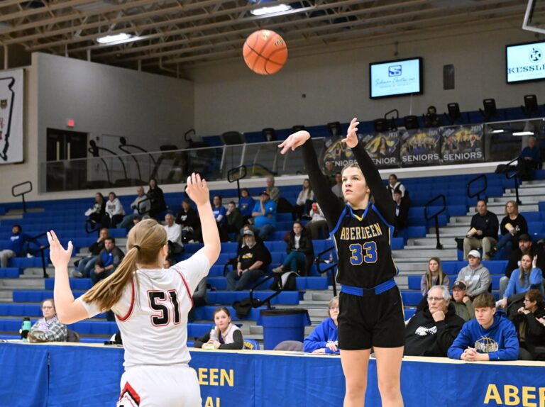Aberdeen Central's Lauryn Burckhard makes a three-pointer in the first quarter in front of Sturgis defender Addy Kossler Saturday, Dec. 21 in Golden Eagles Arena. With the win, the Eagles are now 3-1. Aberdeen Insider photo by Robb Garofalo.