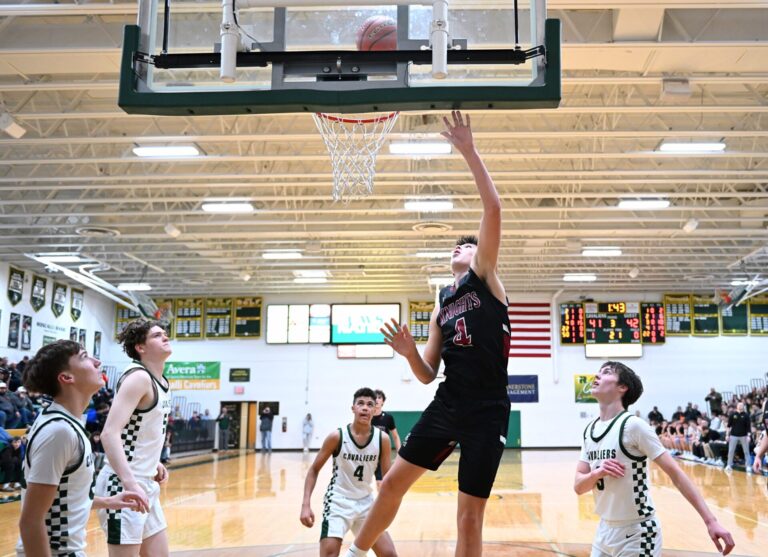 Aberdeen Christian's Brooks Jett scores in front of Aberdeen Roncalli's Aiden Fisher, right, Sam Franks, Cam Olson, and Bryson Olson during the third quarter of the Knights' 72-60 overtime win. Aberdeen Insider photo by Robb Garofalo.