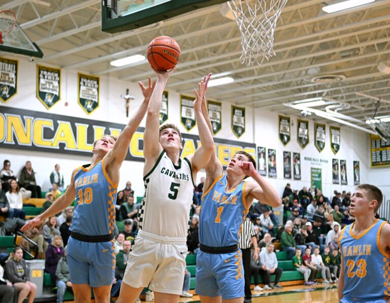 Aberdeen Roncalli's Brody Weinmeister drives to the hoop between Hamlin's Evan Stormo, left, and Boden Stevenson during the second quarter Tuesday, Feb. 11 inside Roncalli Gym. Hamlin, the defending Class A state champs, pulled away early for a 65-30 win. Aberdeen Insider photo by Robb Garofalo.