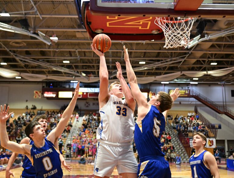 Castlewood's Bryon Laue takes a jump hook over Colby Flowers of Wessington Springs during their State B semifinal Friday, March 21 inside Wachs Arena. Castlewood won 64-45. Aberdeen Insider photo by Robb Garofalo.