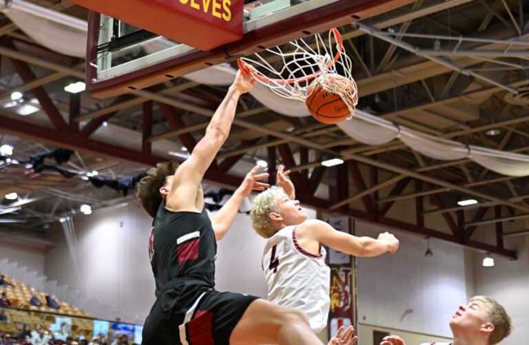 Aberdeen Christian's Brooks Jett throws down a one-hand slam over Lyman's Askel Ehlers during their State B seventh-place game Saturday, March 22 at Wachs Arena. Jett had 13 points and 11 rebounds in a 64-46 win. Aberdeen Insider photo by Robb Garofalo.