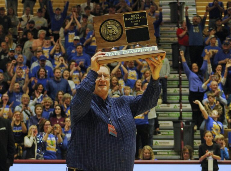 Castlewood head coach Paul Raasch acknowledges the crowd as he holds the State B tournament championship trophy following his team's 52-31 win over Viborg-Hurley Saturday, March 22 inside Wachs Arena. Aberdeen Insider photo by Robb Garofalo