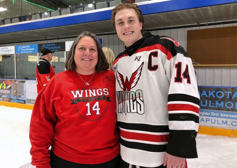 Cathy Kucera joins Luke Backel on the ice following the Aberdeen Wings 4-2 win over St. Cloud Saturday, March 8 inside the Odde ice Center. Kucera is Backel's former middle school lunch lady who has made three trips to South Dakota to watch him play. Aberdeen Insider photo by Robb Garofalo.