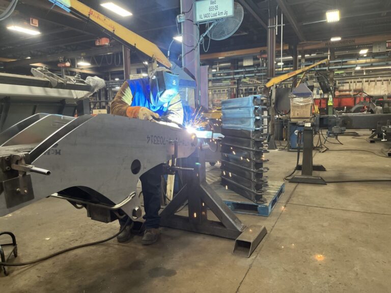 A worker welds together heavy machinery in June 2023 at a Manitou Equipment plant in Madison. The plant was subjected to a "worksite enforcement action" on May 13, 2025, by Immigration and Customs Enforcement. South Dakota Searchlight photo by Joshua Haiar.