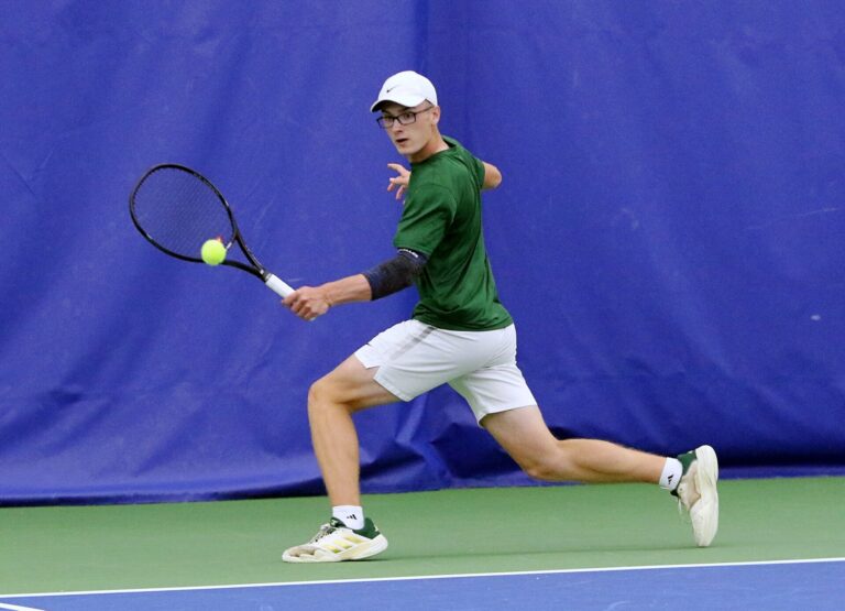 Aberdeen Roncalli's Gannon May reaches for a backhand while playing at the Class A boys state tennis tournament in Sioux Falls. May finished third in top-flight singles as the Cavaliers placed sixth as a team. The tournament was Monday, May 19 and Tuesday, May 20. Photo courtesy of South Dakota Public Broadcasting.