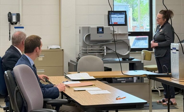 A recount of the Aberdeen City Council election ballots on Monday, June 16 at the Brown County Courthouse confirmed the results of the June 3 election. City Attorney Ron Wager, left, and Finance Officer Jordan McQuillen watch as Brown County Deputy Auditor Stephanie Jacobson runs ballots through the tabulator.  Chad Nilson finished with one more vote than Kurt Preszler. Aberdeen Insider photo by Elisa Sand.