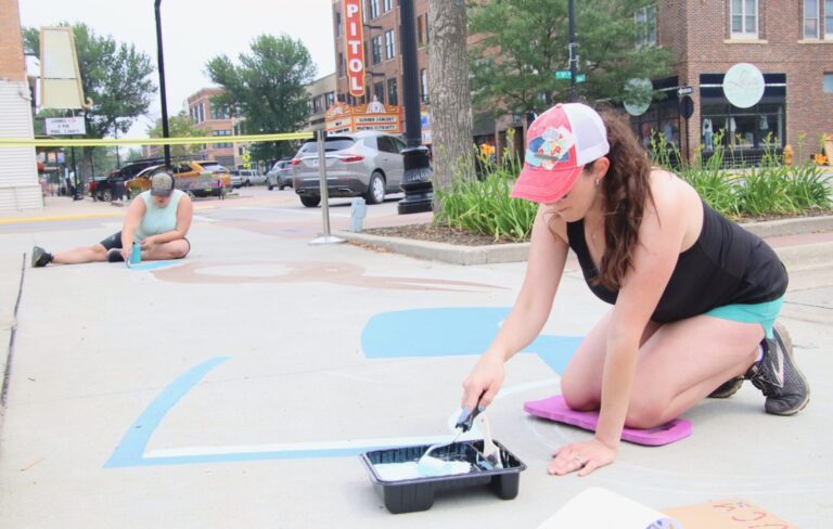 Courtney Erickson, front, and Breanna Kraft, work on a sensory path in front of Malchow Plaza. Aberdeen Insider photo by Elisa Sand.