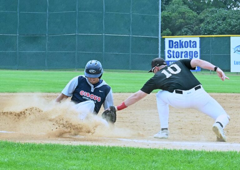 Kris Kwak of the Aberdeen Circus slides and beats the tag of Sioux Falls third baseman Damon Baruth for a two-run triple during a Class A amateur baseball state Tturnament game Sunday, Aug. 10 at Fossum Field. The Circus advanced with a 9-3 win. Aberdeen Insider photo by Robb Garofalo.