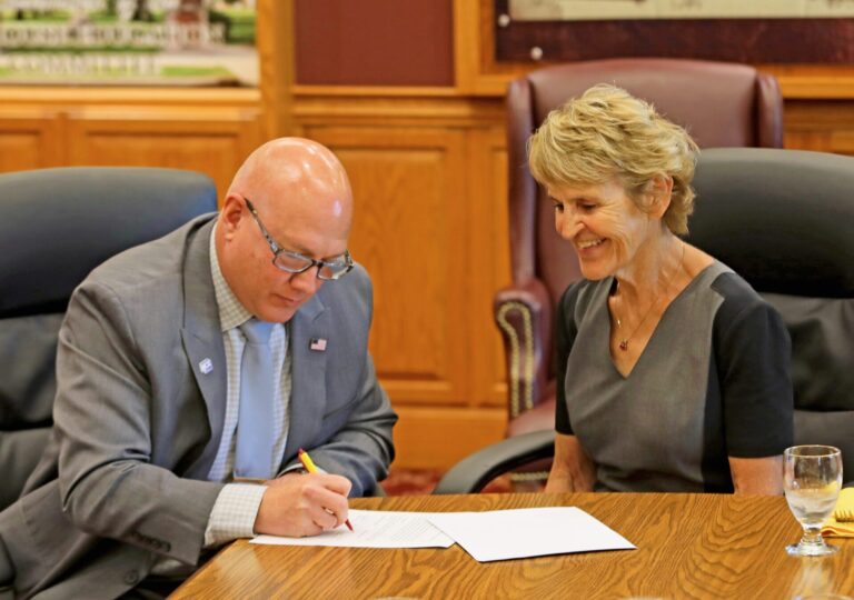 Doug Pietz, executive director at Huron Community Campus, signs the newest memorandum of understanding with Northern State University Interim President Laurie Nichols. With the agreement, Northern provides classes in Huron. Photo courtesy of Northern State University.