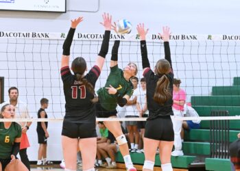 Aberdeen Roncalli's Jillian Ellwein attempts to hit through the block by Aberdeen Christian's Ariana Johnson (11) and Sawyer Schwan during their match Monday, Sept. 22 inside Roncalli Gym. Ellwein had 11 kills in a five-set Cavaliers win. Aberdeen Insider photo by Robb Garofalo