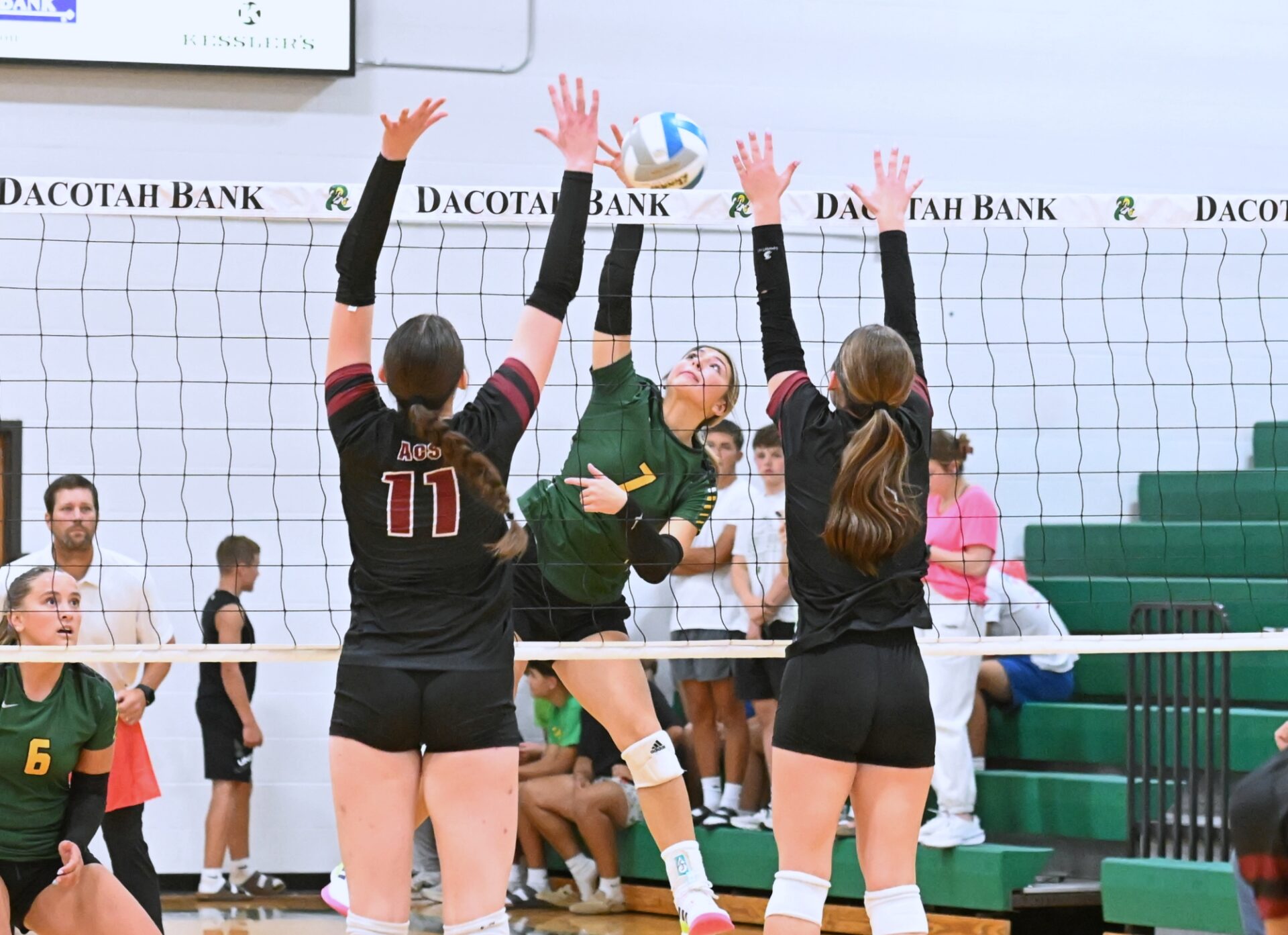 Aberdeen Roncalli's Jillian Ellwein attempts to hit through the block by Aberdeen Christian's Ariana Johnson (11) and Sawyer Schwan during their match Monday, Sept. 22 inside Roncalli Gym. Ellwein had 11 kills in a five-set Cavaliers win. Aberdeen Insider photo by Robb Garofalo