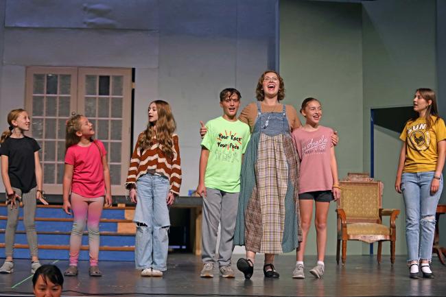 The actors playing the von Trapp children in "The Sound of Music" sing with their new governess Maria Rainer during a rehearsal of the musical on the Johnson Fine Arts Center stage at Northern State University. From left are Gretl, played by Kealey DesCamps); Marta, played by Ella Balgaard; Brigitta, played by Isabella Carlson; Kurt, played by Gabe Cogley; Maria, played by Hannah Gasperich; Louisa, played by Eden Barkmeier; and Liesl, played by Lexie Johnson. Missing is Friedrich, played by Haydler Schiferl. Courtesy photo.