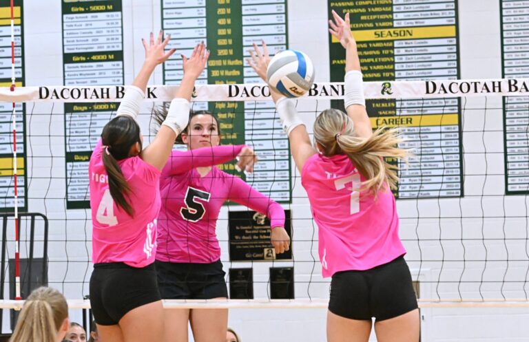 Aberdeen Roncalli's Gabby Thomas hits through the block attempt of Mobridge-Pollock's Pacey Konold and Blake Thompson during the second set of a three-set sweep by Roncalli Tuesday, Oct. 14 inside Roncalli Gym. Aberdeen Insider photo by Robb Garofalo.