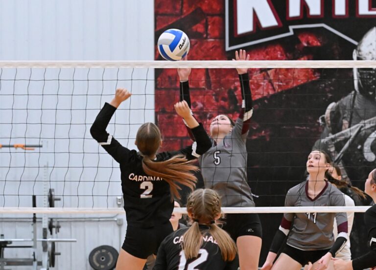 Ellenadale's Kinsey Middlestead (2) and Aberdeen Christian's Sawyer Schwan wait to see what side of the net the ball drops on during the first set of their match Friday, Oct 24 at the Aberdeen Christian Gym. The Knights won the match in four sets. Aberdeen Insider photo by Robb Garofalo.