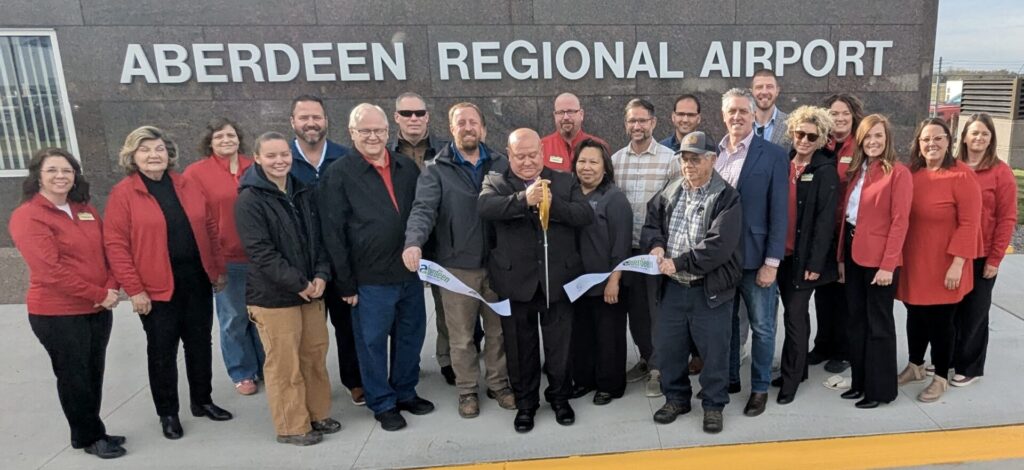 Aberdeen Transportation Director Rich Krokel cuts the ribbon during a ceremony on Thursday, Nov. 6 in recognition of work to rebuild the airport parking lot and access road being substantially complete. Aberdeen Insider photo by Scott Waltman.