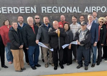 Aberdeen Transportation Director Rich Krokel cuts the ribbon during a ceremony on Thursday, Nov. 6 in recognition of work to rebuild the airport parking lot and access road being substantially complete. Aberdeen Insider photo by Scott Waltman.